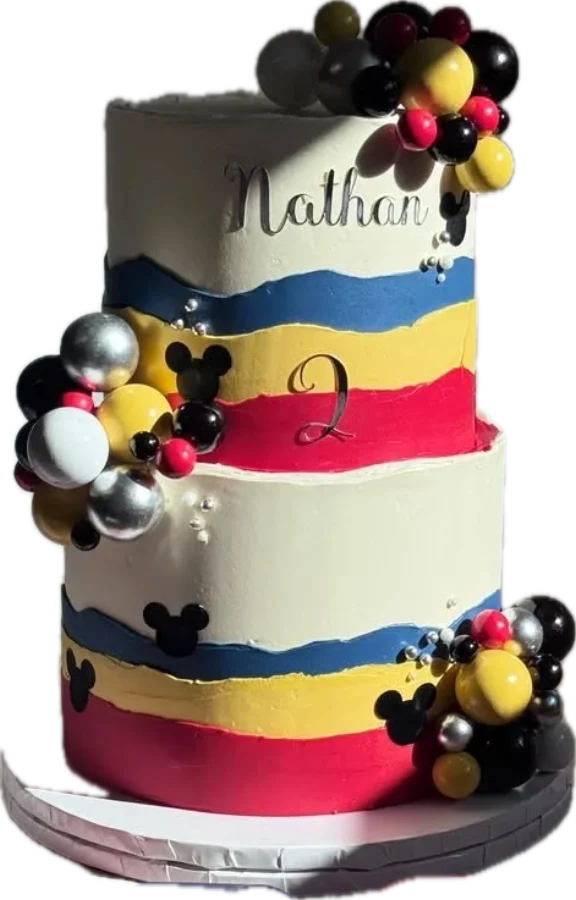 Zweistöckige Torte mit Streifen in Rot, Gelb und Blau, Mickey-Köpfen und dem Namen Nathan